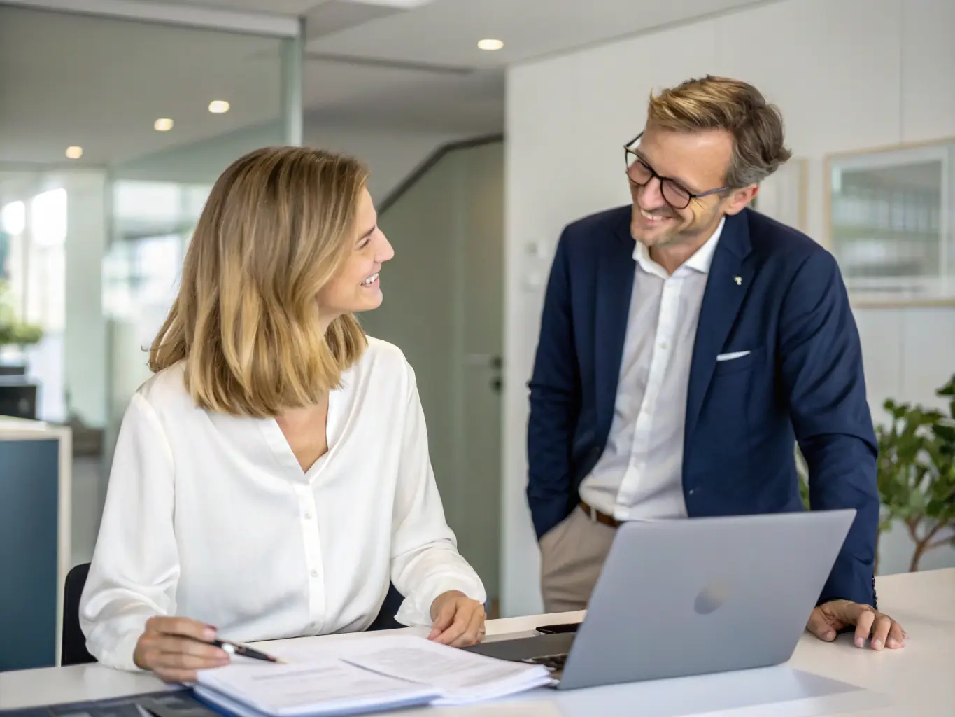 A person sitting at a desk, reviewing financial documents with a financial advisor in a bright, modern office setting. The focus is on the collaborative aspect of financial planning.